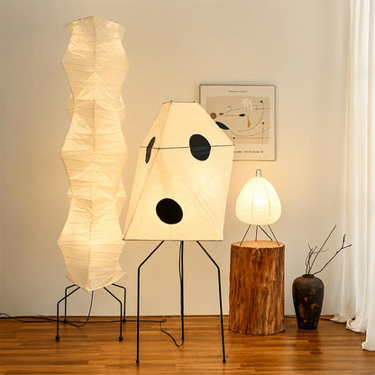 Warm glowing paper lantern standing lamp featured alongside organic floor lights in a showroom.