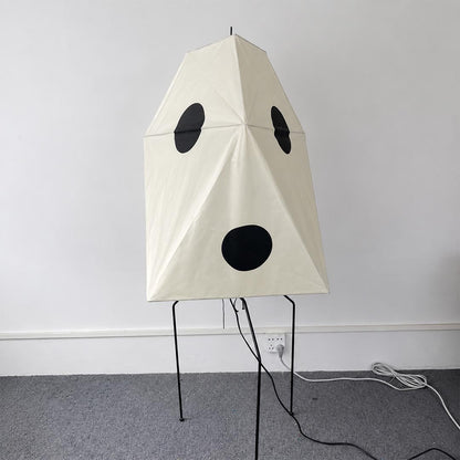 Geometric Wabi-Sabi paper lantern floor lamp with a tripodal metal base in a clean white space.