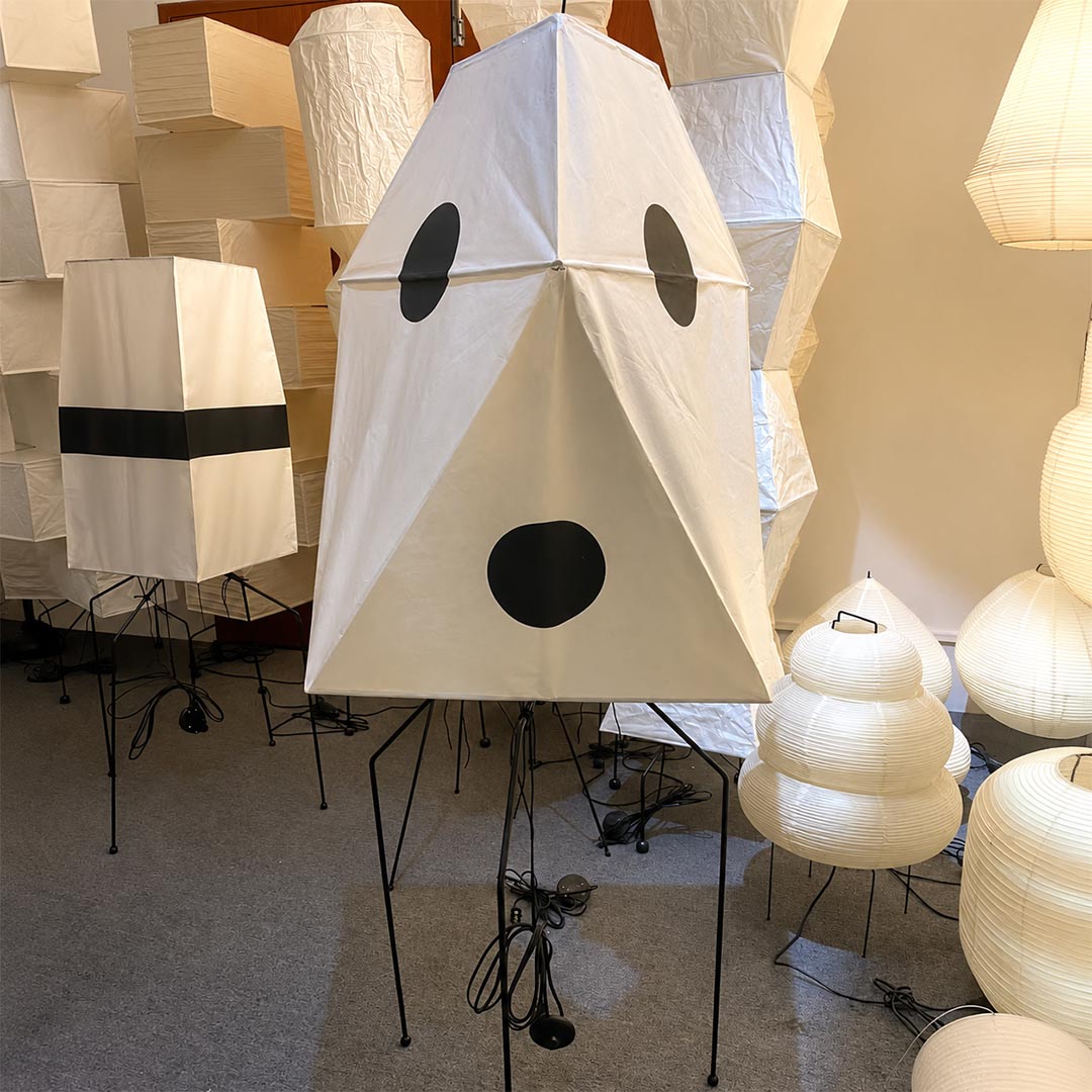 Japanese Akari style geometric paper floor lamp displayed alongside handcrafted paper light fixtures.