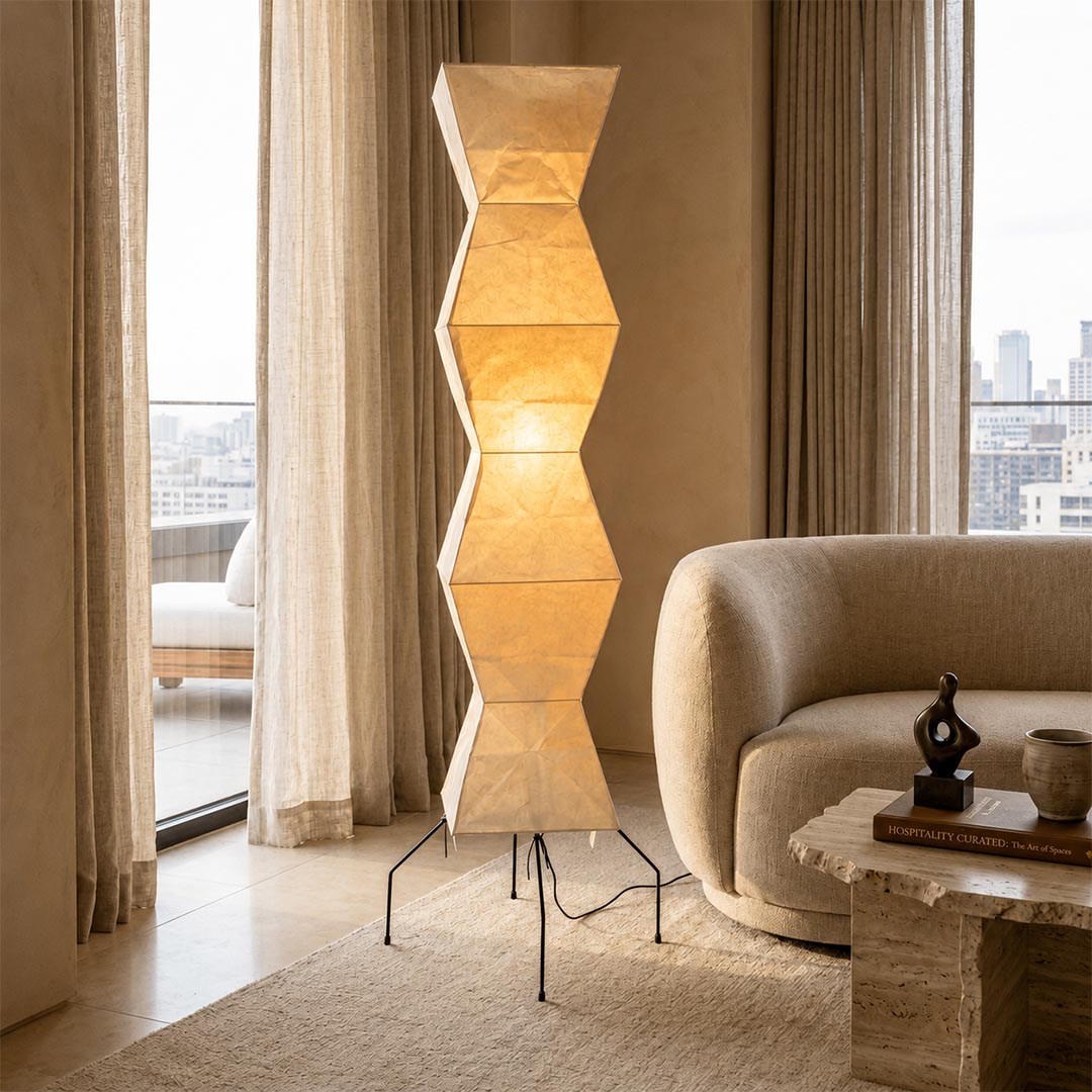 Sculptured Akari UF4-L9 Floor Lamp casting warm light next to a modern curved sofa by an expansive window by Stuber Lighting.