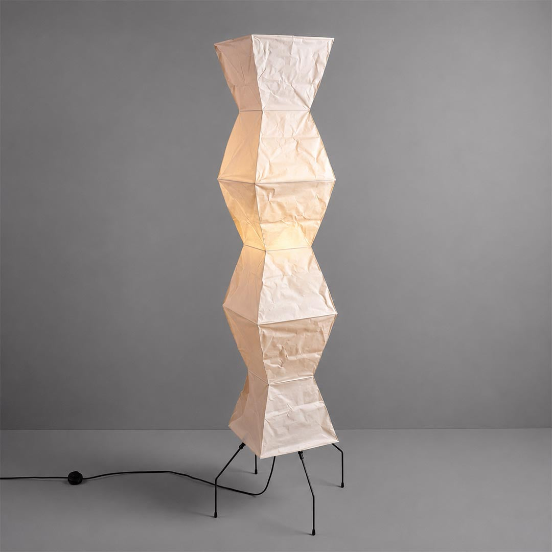 Studio shot of an illuminated geometric Akari UF4-L9 Floor Lamp against a solid grey background by Stuber Lighting.