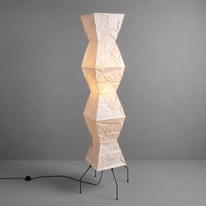 Studio shot of an illuminated geometric Akari UF4-L9 Floor Lamp against a solid grey background by Stuber Lighting.