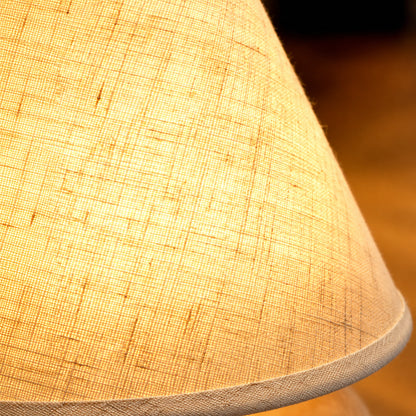 Close-up of the woven fabric shade glowing on the Alberello table lamp