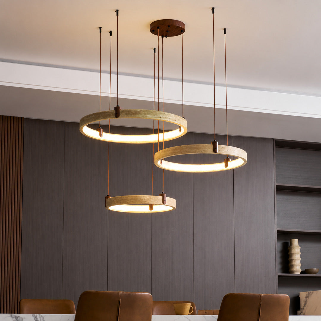 Anelli travertine chandelier living room double height open space warm glow travertine stone rings sculptural American home lifestyle interior styled