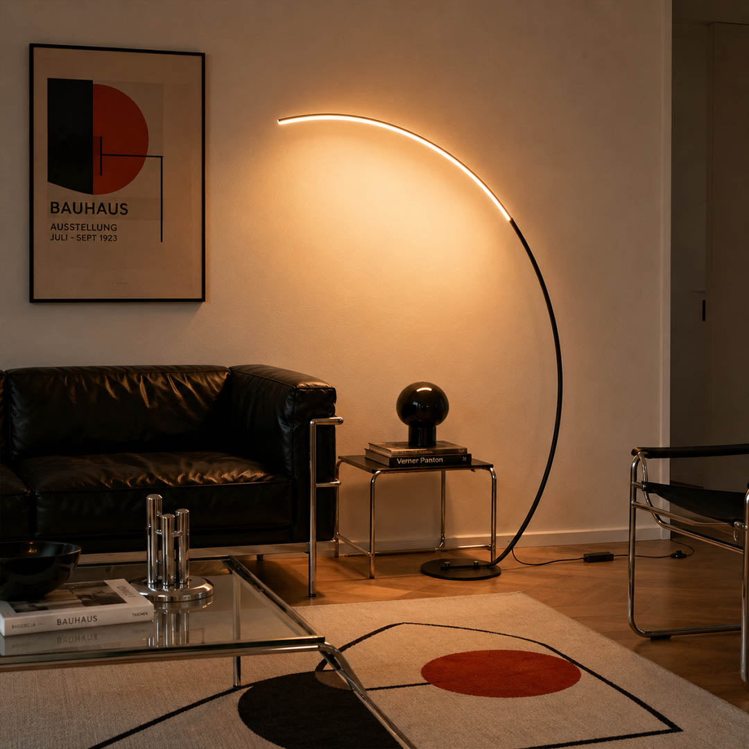 Arco floor lamp black modern living room sectional sofa overhead reach arc curved statement mid century Italian minimalist warm ambient sculptural elegant lifestyle interior