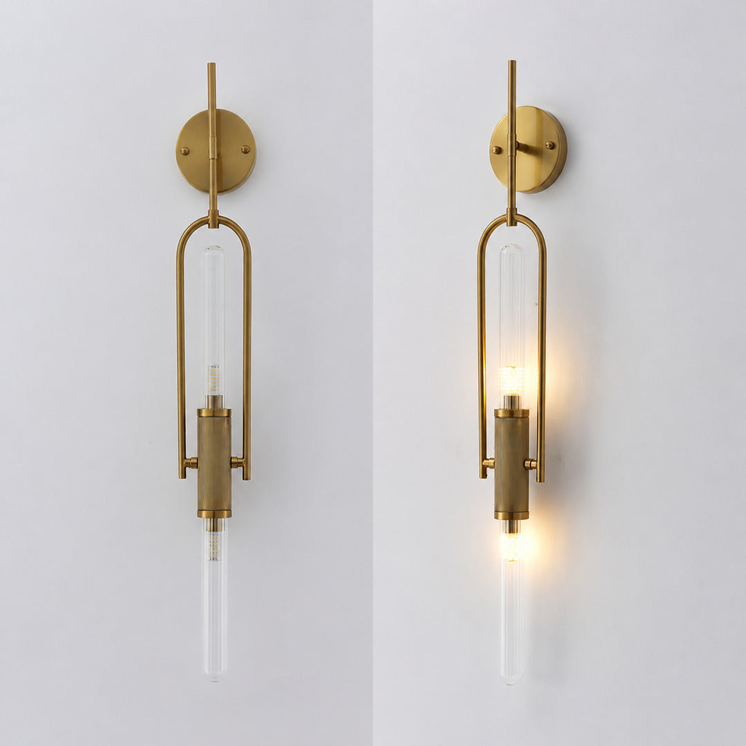 Warm light glowing through the clear glass cylinder of the Arco wall sconce