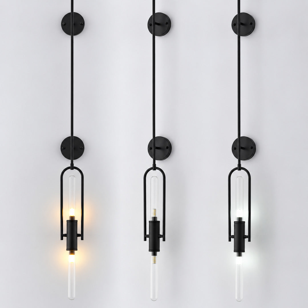Warm light glowing through the clear glass cylinder of the Arco wall sconce