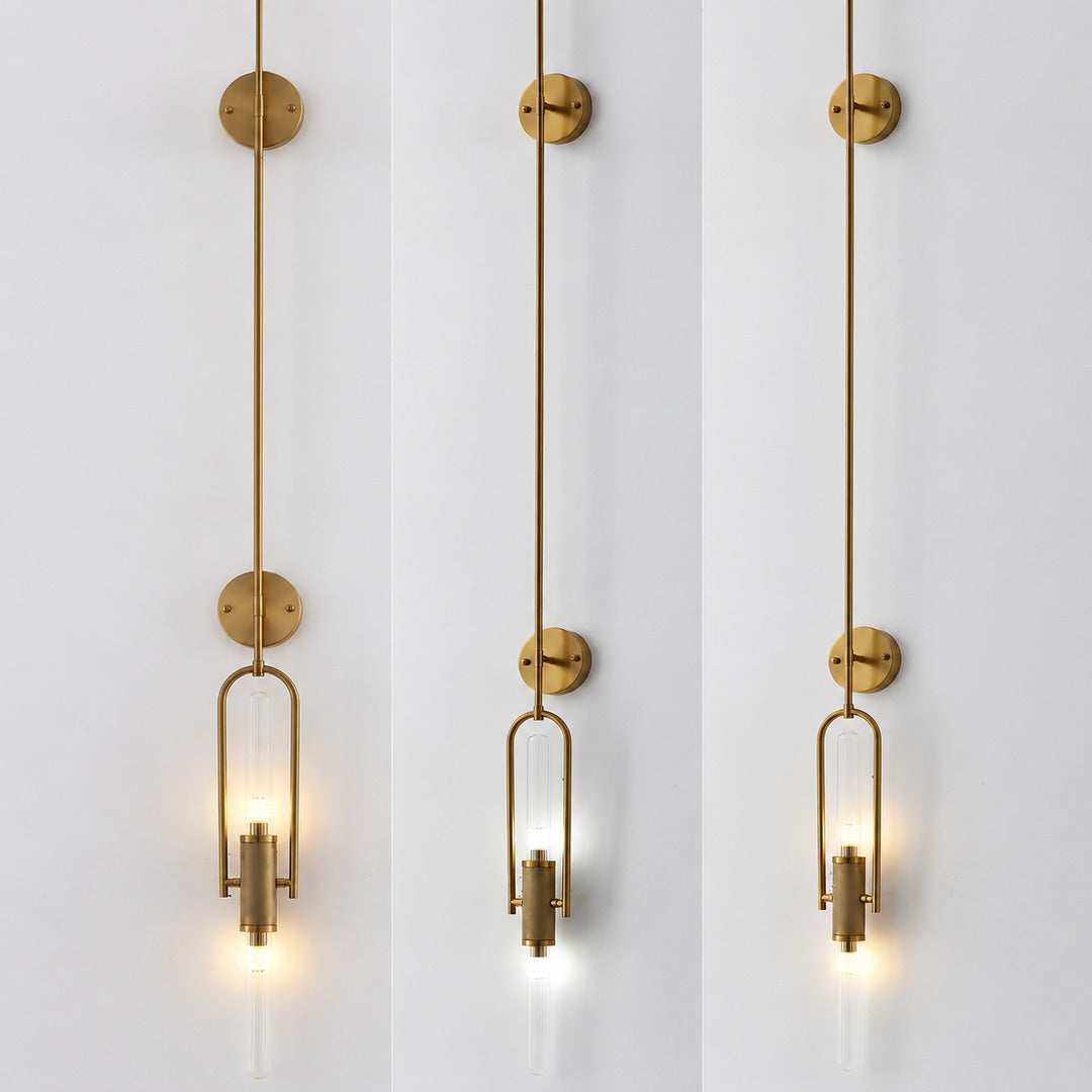 Warm light glowing through the clear glass cylinder of the Arco wall sconce