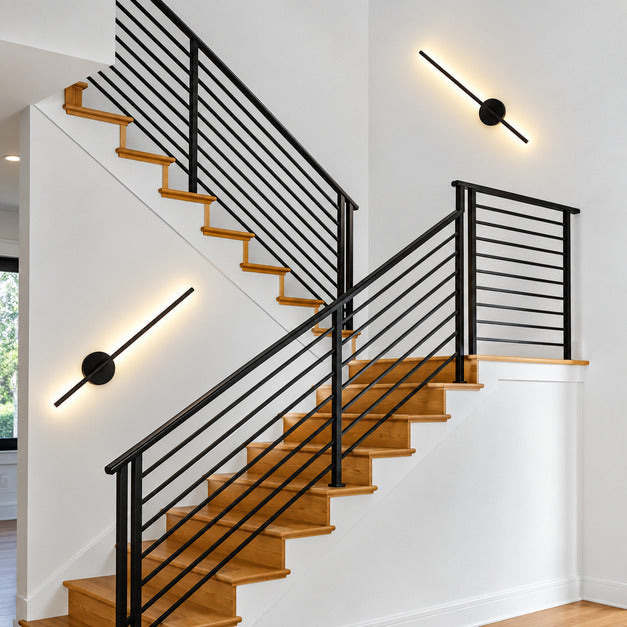 Tall Asse rechargeable wall sconce lighting a staircase wall as a slim vertical accent