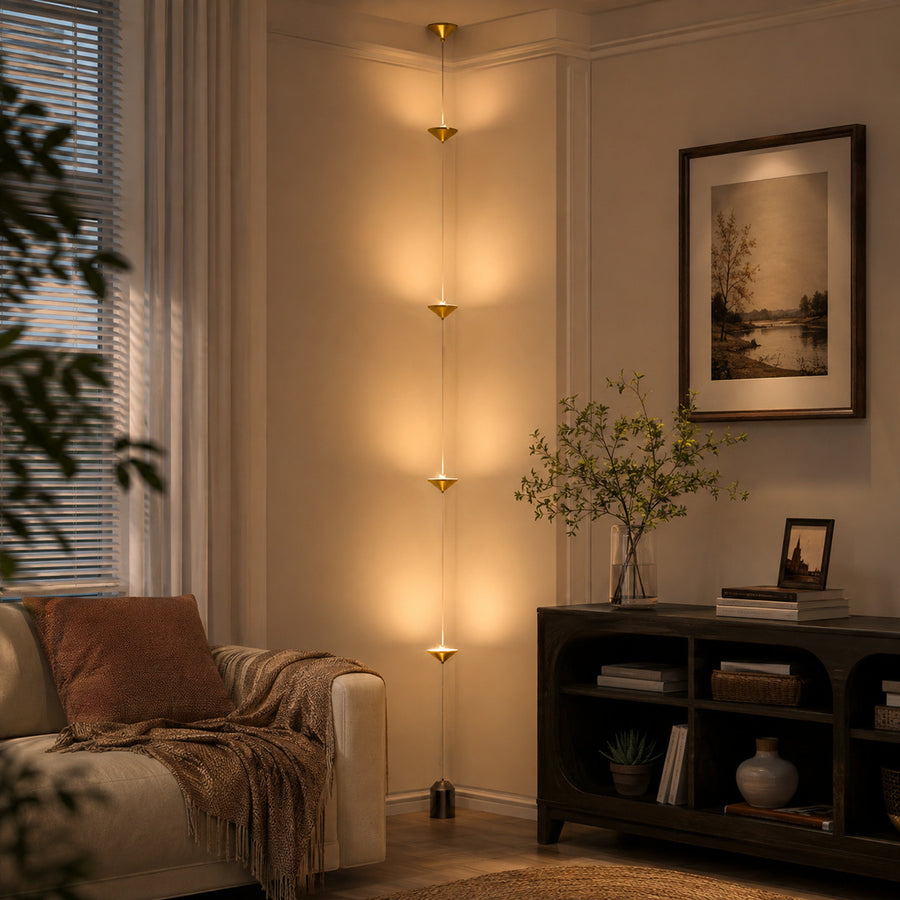 Asta floor lamp living room beside sofa warm glow gold black floor to ceiling minimalist sculptural American home lifestyle interior styled