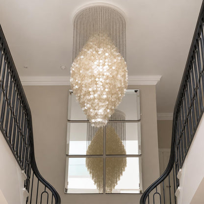 Luxurious contemporary glass pendant light in a modern hallway with natural light and olive trees.