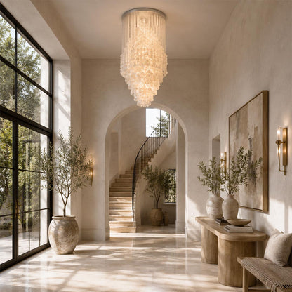 Luxurious contemporary glass pendant light in a modern hallway with natural light and olive trees.