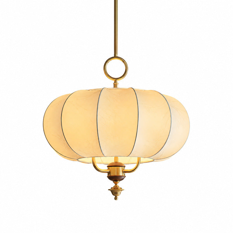 Warm diffused glow through the beige fabric panels of the Belle lantern pendant