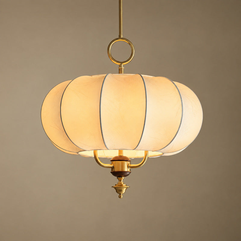 Warm diffused glow through the beige fabric panels of the Belle lantern pendant