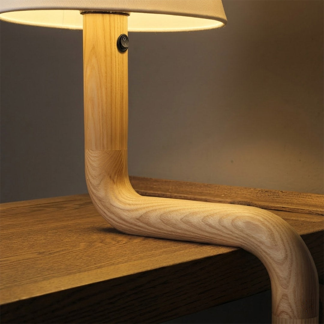 Modern bent wood table lamp with warm ambient LED lighting by Stuberlighting