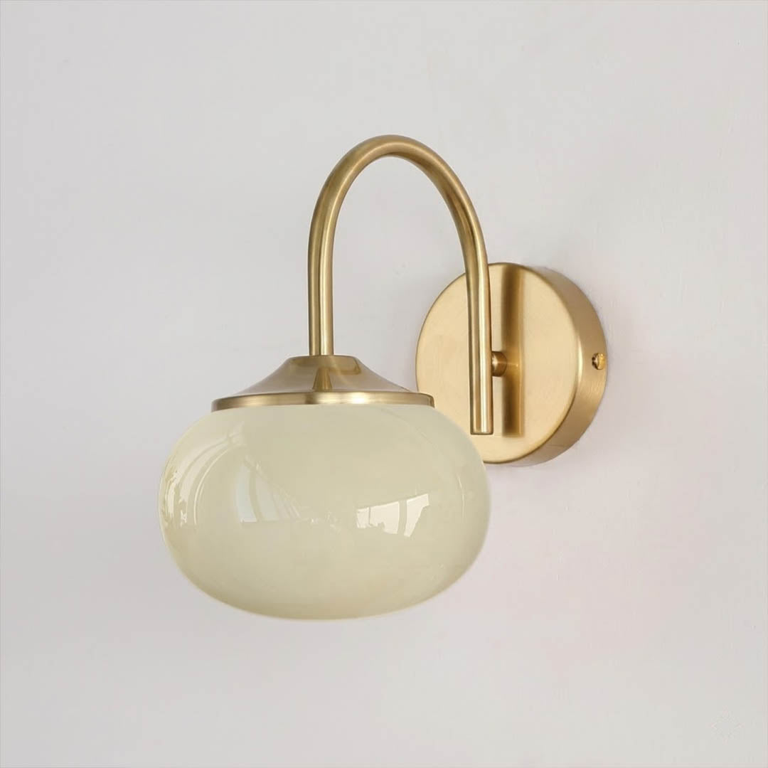 Bonbon wall sconce antique brass bow beige glass globe vintage white background