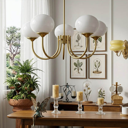 Bonbon glass globe chandelier above dining table warm glow modern interior