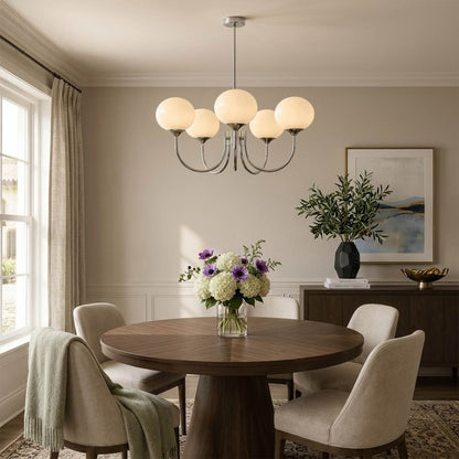Bonbon glass globe chandelier above dining table warm glow modern interior