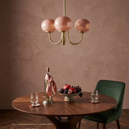 Bonbon glass globe chandelier above dining table warm glow modern interior