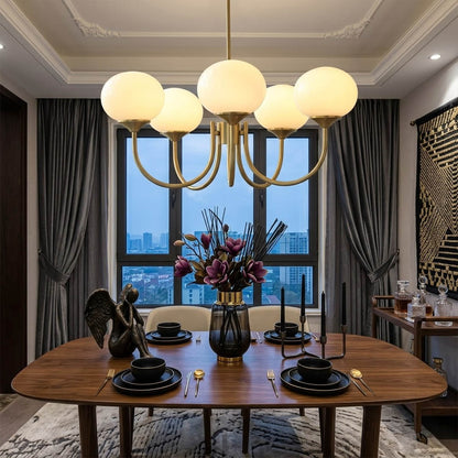Bonbon glass globe chandelier above dining table warm glow modern interior