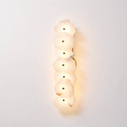 Calcaria alabaster wall light illuminated warm glow translucent natural stone gold organic soft radiance white background