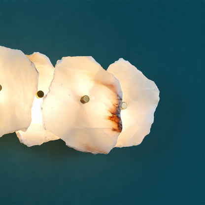 Calcaria alabaster wall light illuminated glowing veining warm soft radiance translucent stone detail close up quiet luxury