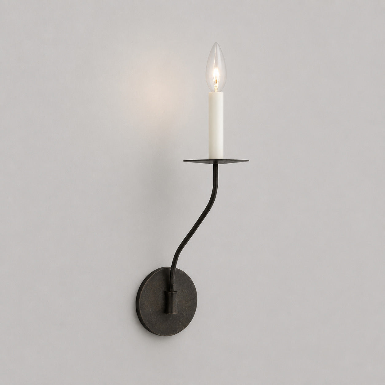 Candela wall sconce short single light matte black finish candle style exposed E14 bulb compact arm round backplate minimalist white background front view