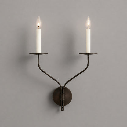 Candela wall sconce two light matte black finish candle style dual exposed E14 bulbs twin curved arms wide backplate minimalist white background front view