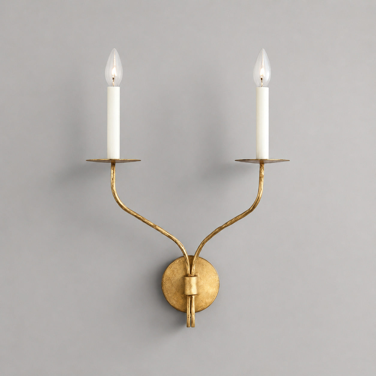 Candela wall sconce two light aged brass finish candle style dual exposed E14 bulbs curved twin arms wide round wall plate vintage mid century white background front view