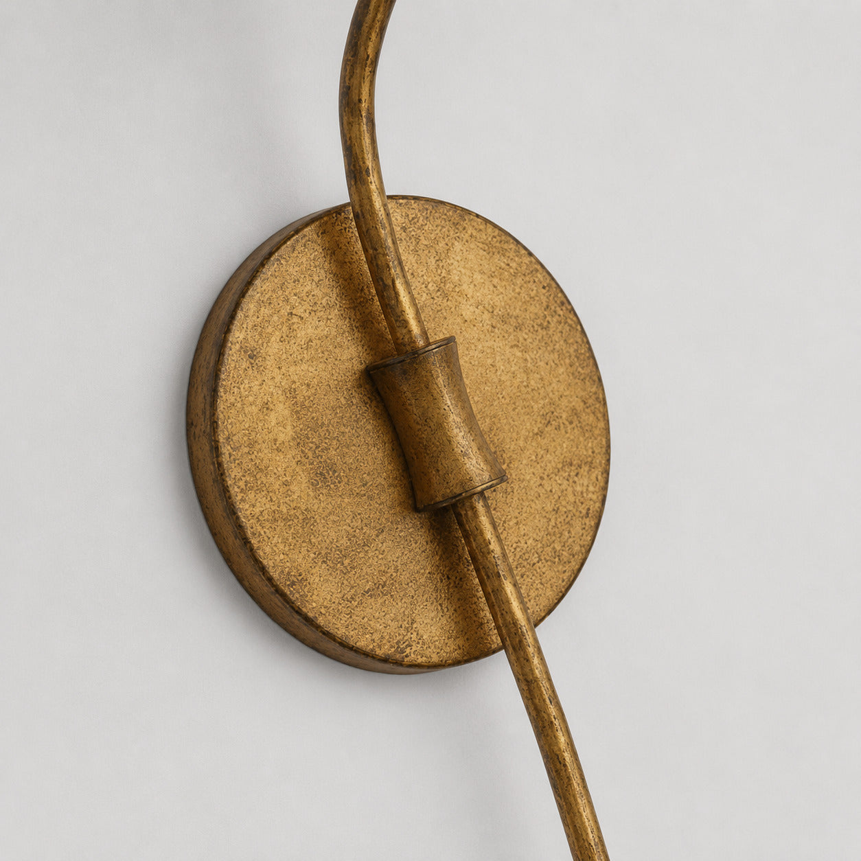 Candela wall sconce aged brass distressed antique finish patina texture surface detail close up craftsmanship