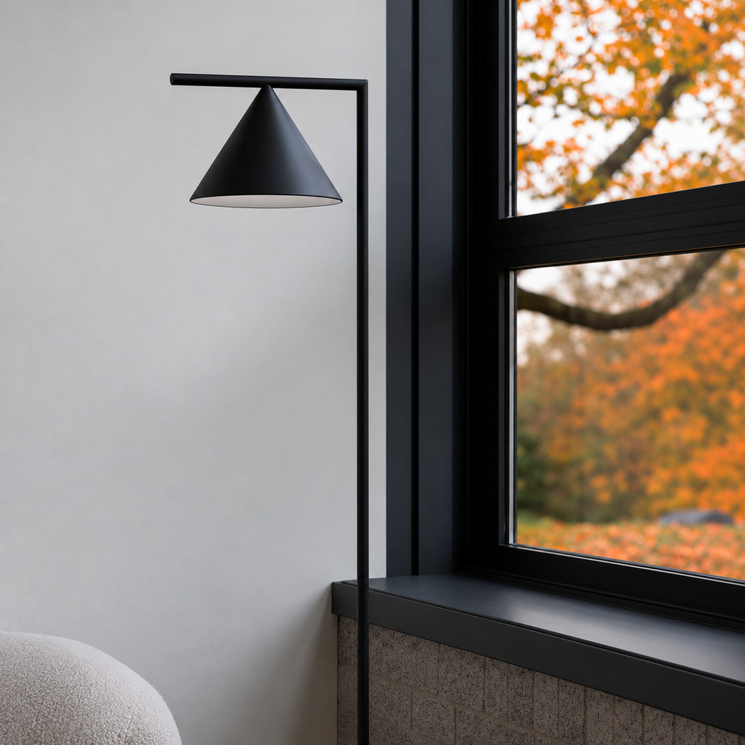 Girevole marble floor lamp with its cone rotated up to wash a wall with warm light
