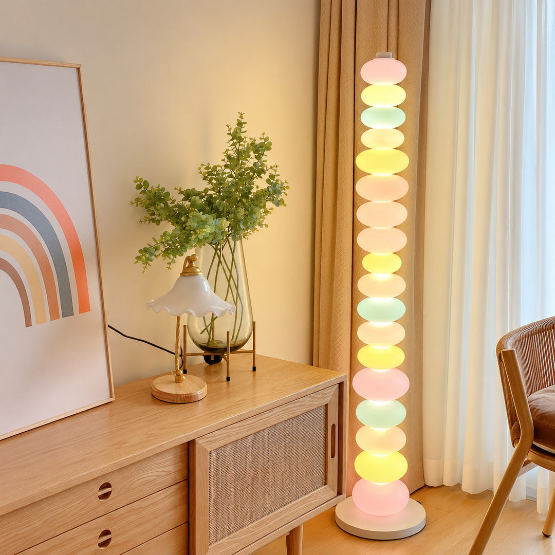 Caramella glass floor lamp filling a living room corner with a warm colorful glow