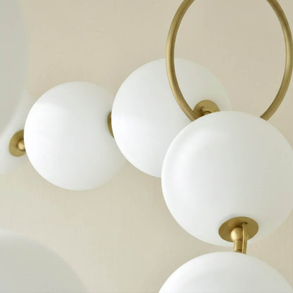 Cascadia chandelier pearl finished glass globes brass arc detail close up