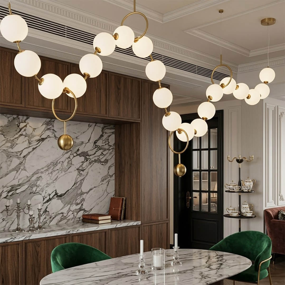 Cascadia horizontal chandelier above long dining table pearl globes warm glow elegant interior