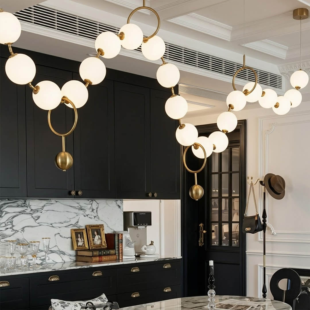 Cascadia linear chandelier above long kitchen island pearl globes modern interior