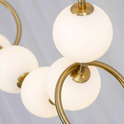 Cascadia chandelier pearl finished glass globes brass arc detail close up