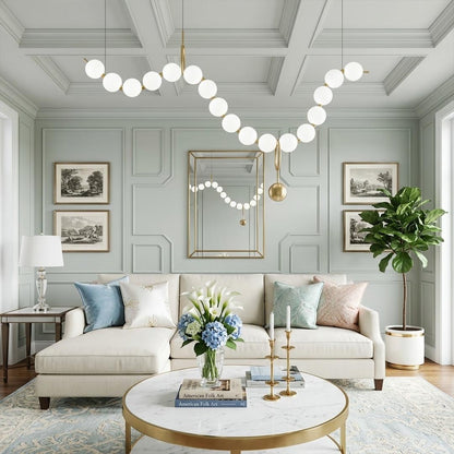 Cascadia horizontal chandelier above long dining table pearl globes warm glow elegant interior