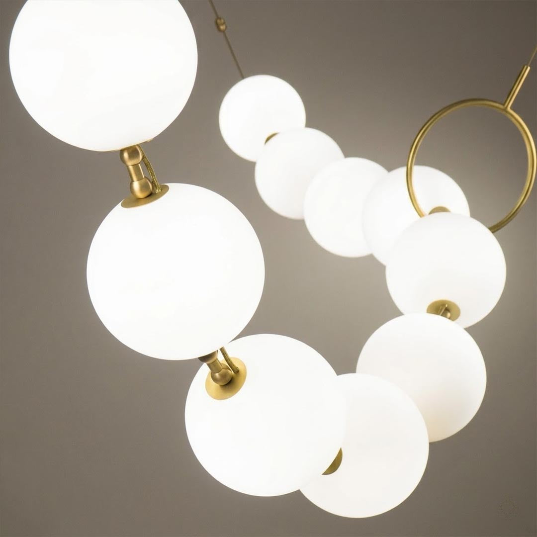 Cascadia chandelier pearl finished glass globes brass arc detail close up