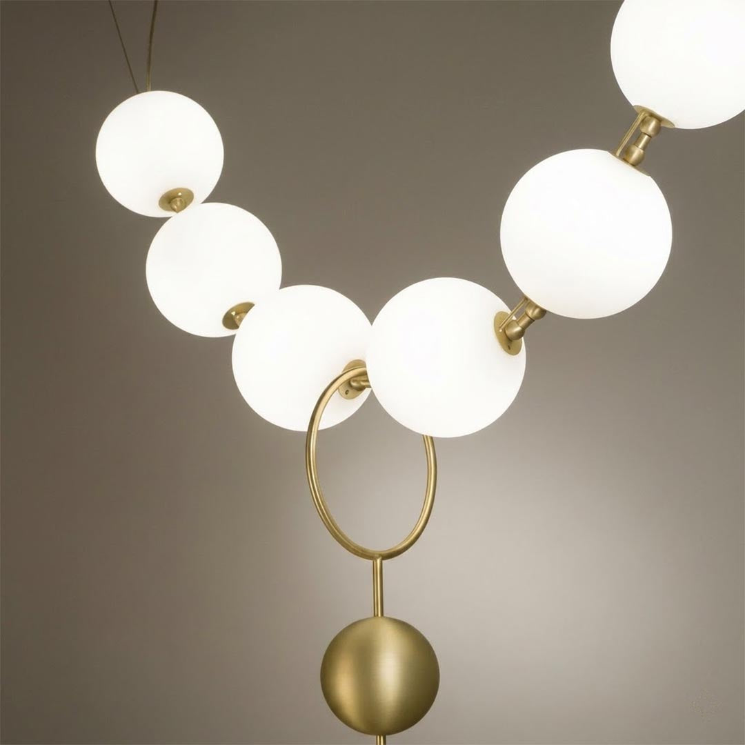 Cascadia chandelier pearl finished glass globes brass arc detail close up