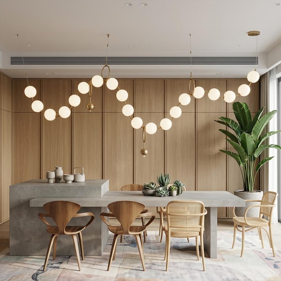 Cascadia horizontal chandelier above long dining table pearl globes warm glow elegant interior