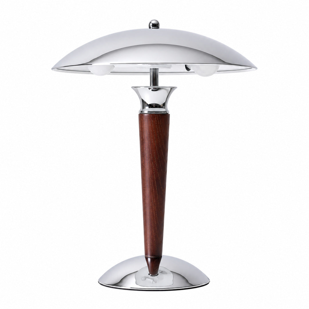 Casco wood table lamp with a polished chrome dome shade on a solid walnut stem glowing warm on a desk