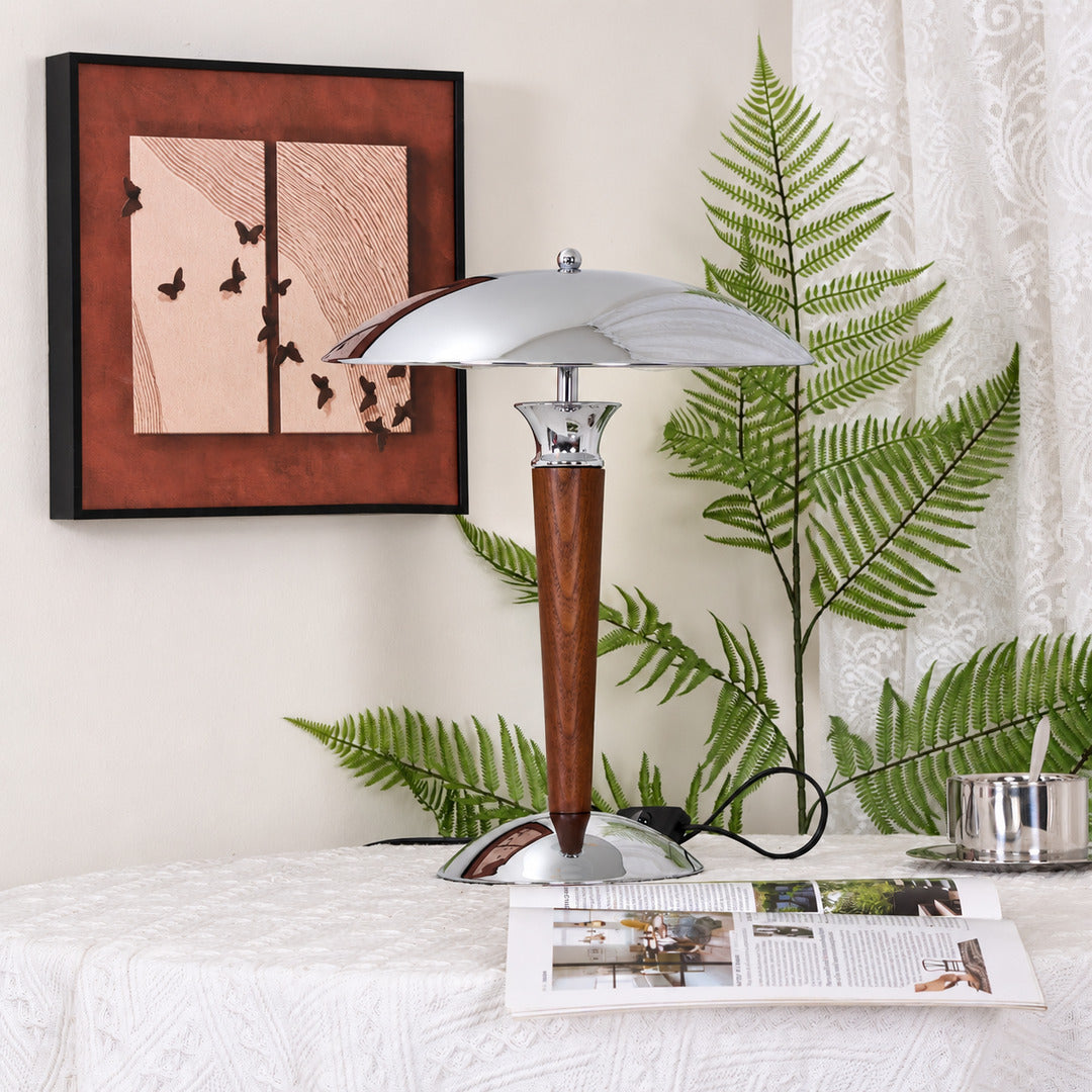 Casco chrome and walnut table lamp providing warm focused light on a home office desk