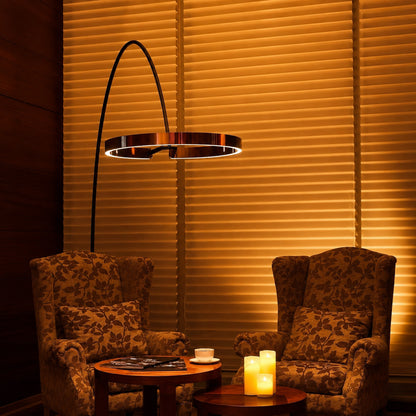 Cerchio halo ring floor lamp casting a soft warm glow over a corner reading chair
