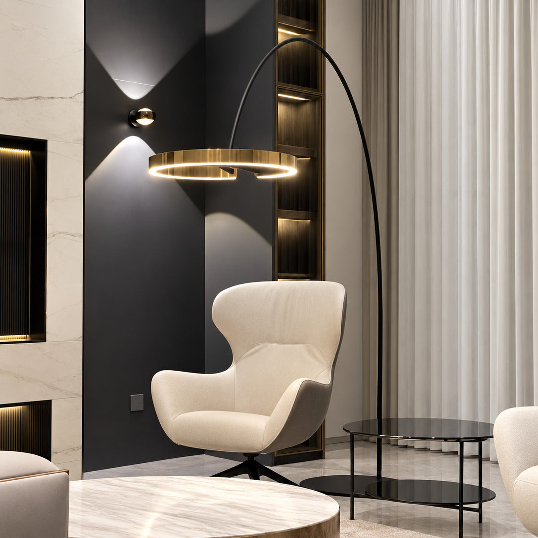 Cerchio halo ring floor lamp casting a soft warm glow over a corner reading chair