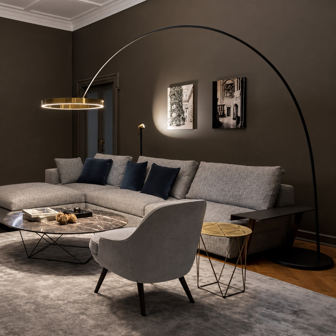 Cerchio halo ring floor lamp standing beside a sofa as a modern sculptural accent in a living room