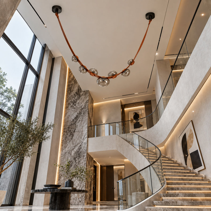 Cinghia leather arc chandelier suspended in an open staircase stairwell