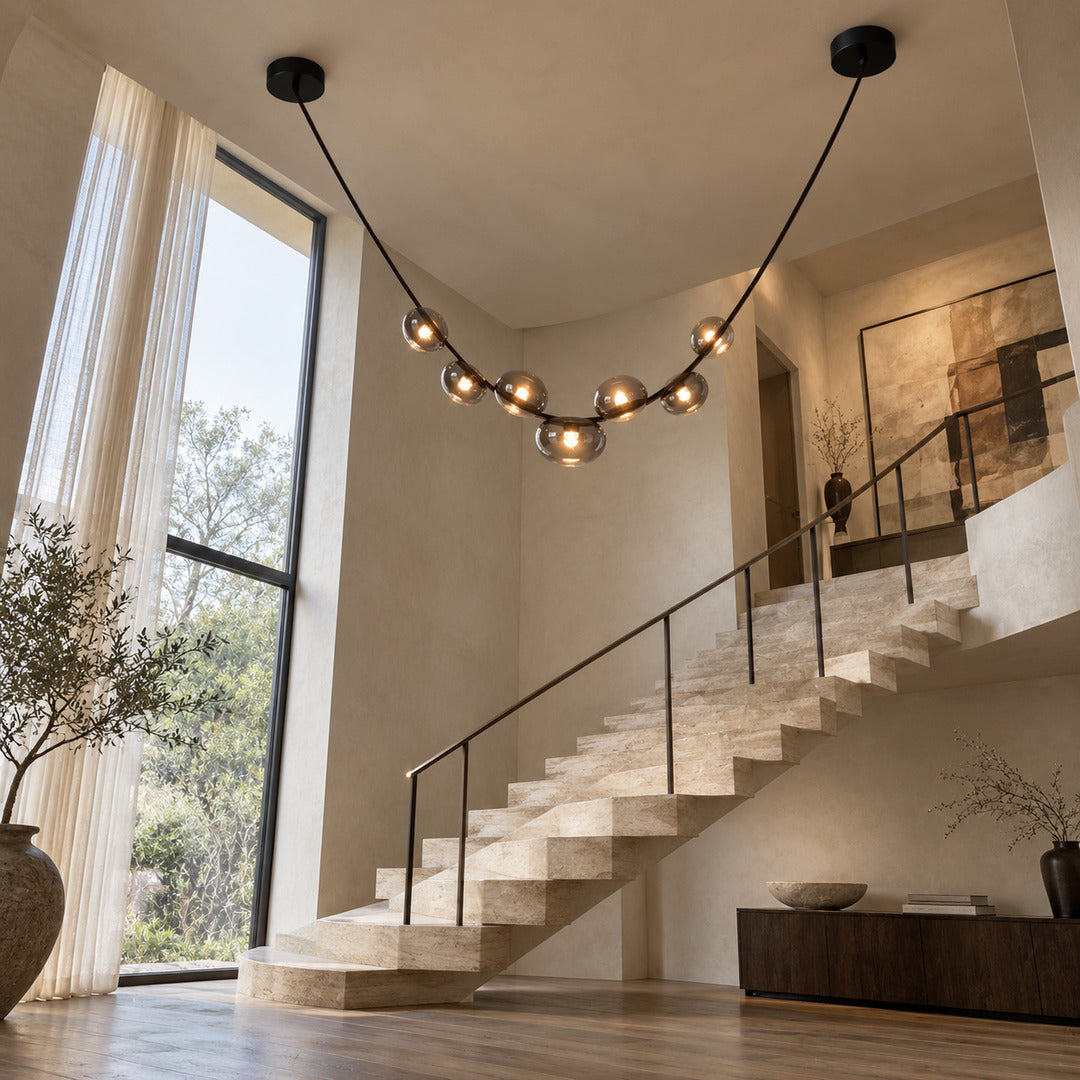 Cinghia leather arc chandelier suspended in an open staircase stairwell
