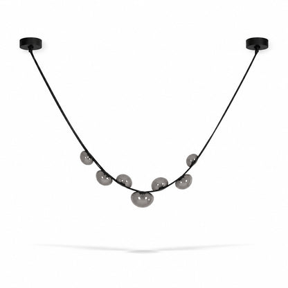 Single strip black and grey Cinghia leather arc chandelier over a dining table