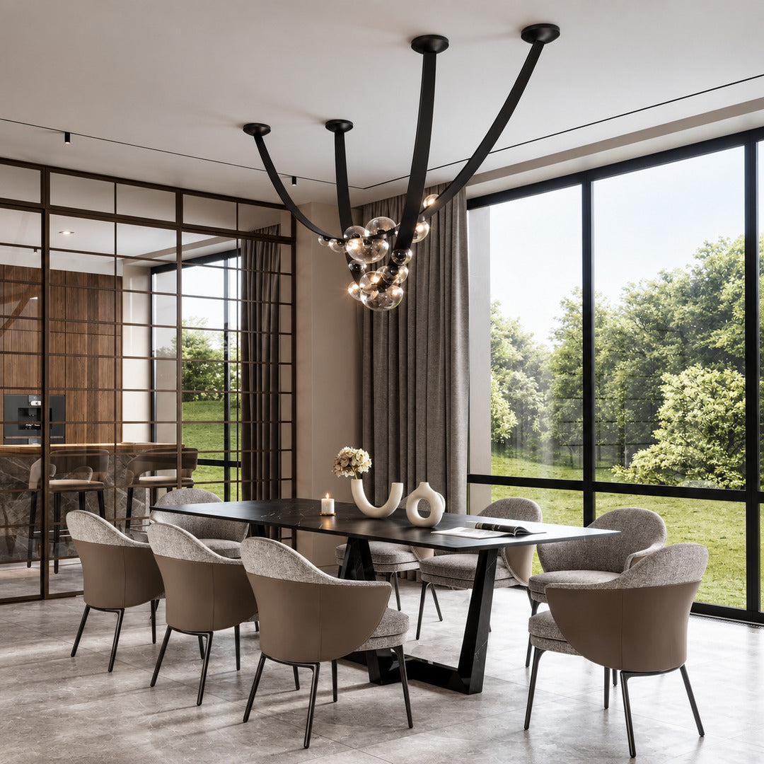 Cinghia leather arc chandelier casting a warm glow over a long dining table