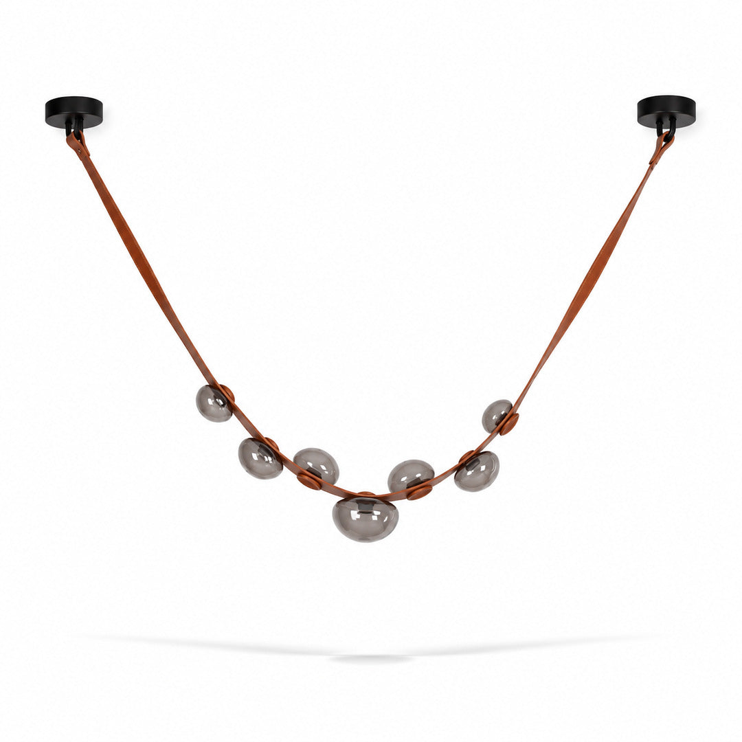 Single strip brown and grey Cinghia leather arc chandelier adding warmth to a mid-century dining room